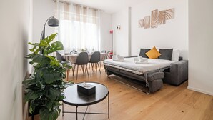 A modern hotel room with a bed, a desk, a dining area, and a large green plant. - COMO Centro Luxury suites just steps from the lake (Como)
