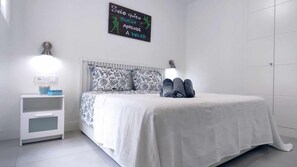 A bedroom with a bed, two bedside tables, a wall-mounted light, and a motivational quote. - Panorama Beach - Blue Horizon (Torrox)