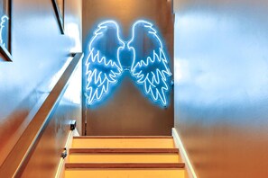 A staircase with a neon sign of angel wings. - Lux Nash Party•10 Beds•Hot Tub•Game Room + Pool (Nashville)