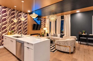 A modern living room with a central island, a sofa, and a dining area. - Lux Nash Party•10 Beds•Hot Tub•Game Room + Pool (Nashville)