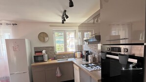 Una cocina moderna equipada con refrigerador, microondas, estufa y pileta.