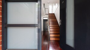 A modern interior with a wooden staircase, a glass door, and a black door. - Copperstone Corner, Richmond (Richmond)