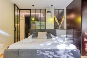 Una camera da letto moderna con un letto grande, un comodino e vista attraverso una porta scorrevole.
