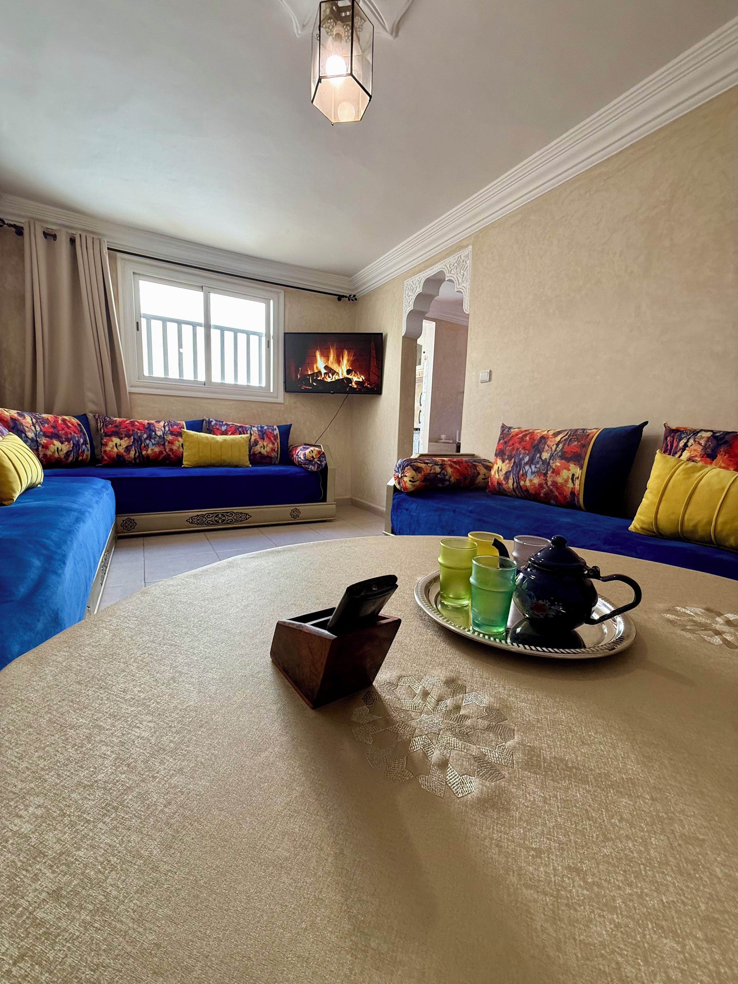 Ein Wohnzimmer mit zwei Sofas, einem Couchtisch, einem Fernseher und einem Kamin.