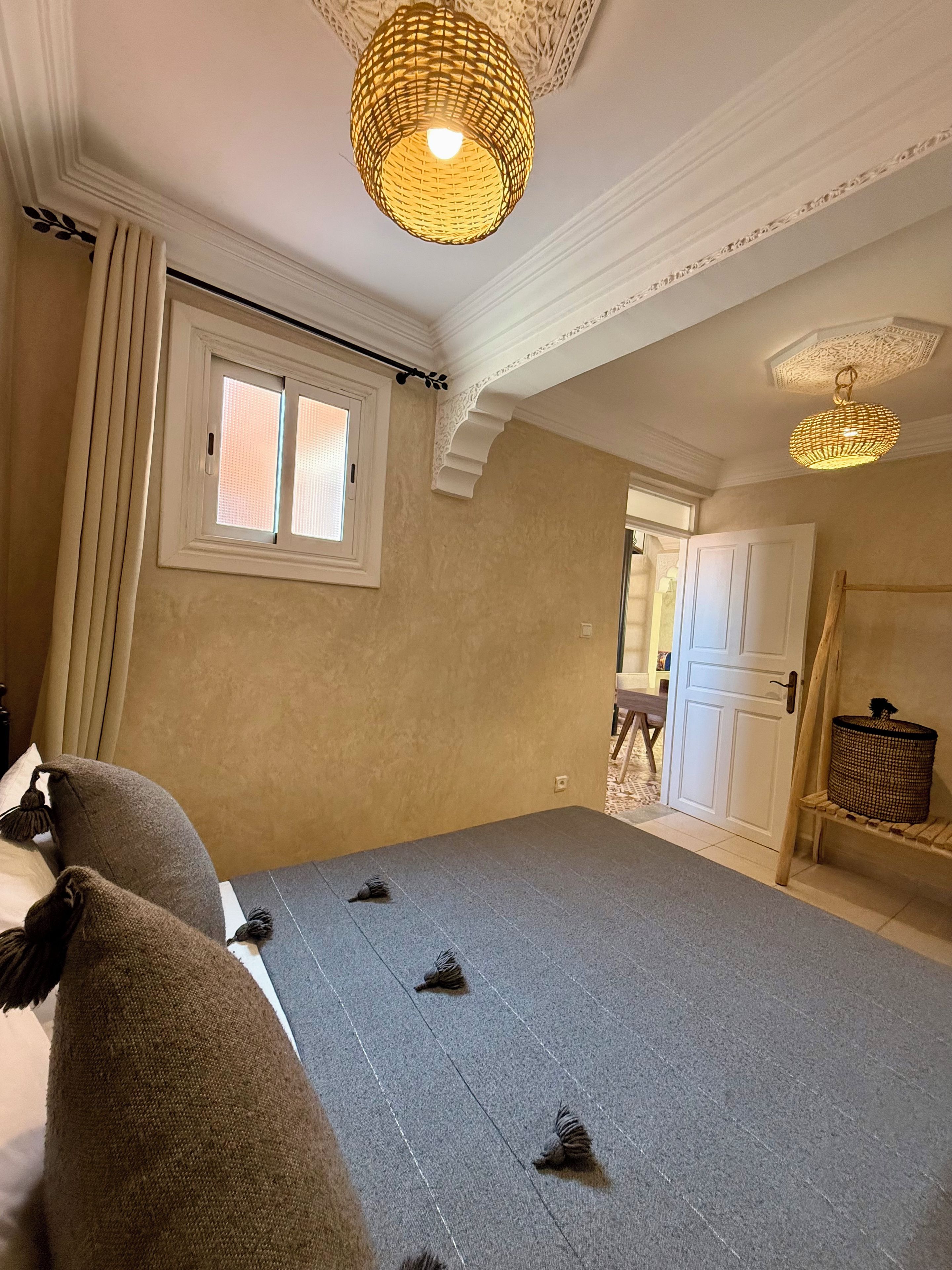 Ein Zimmer mit großem Fenster, einer Tür und einer Deckenleuchte.