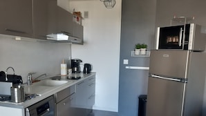 Eine moderne Küche mit Edelstahlgeräten, einem Geschirrspüler und einer Kaffeemaschine.