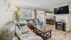 Una sala de estar con sofá, mesa de centro, televisor y chimenea.