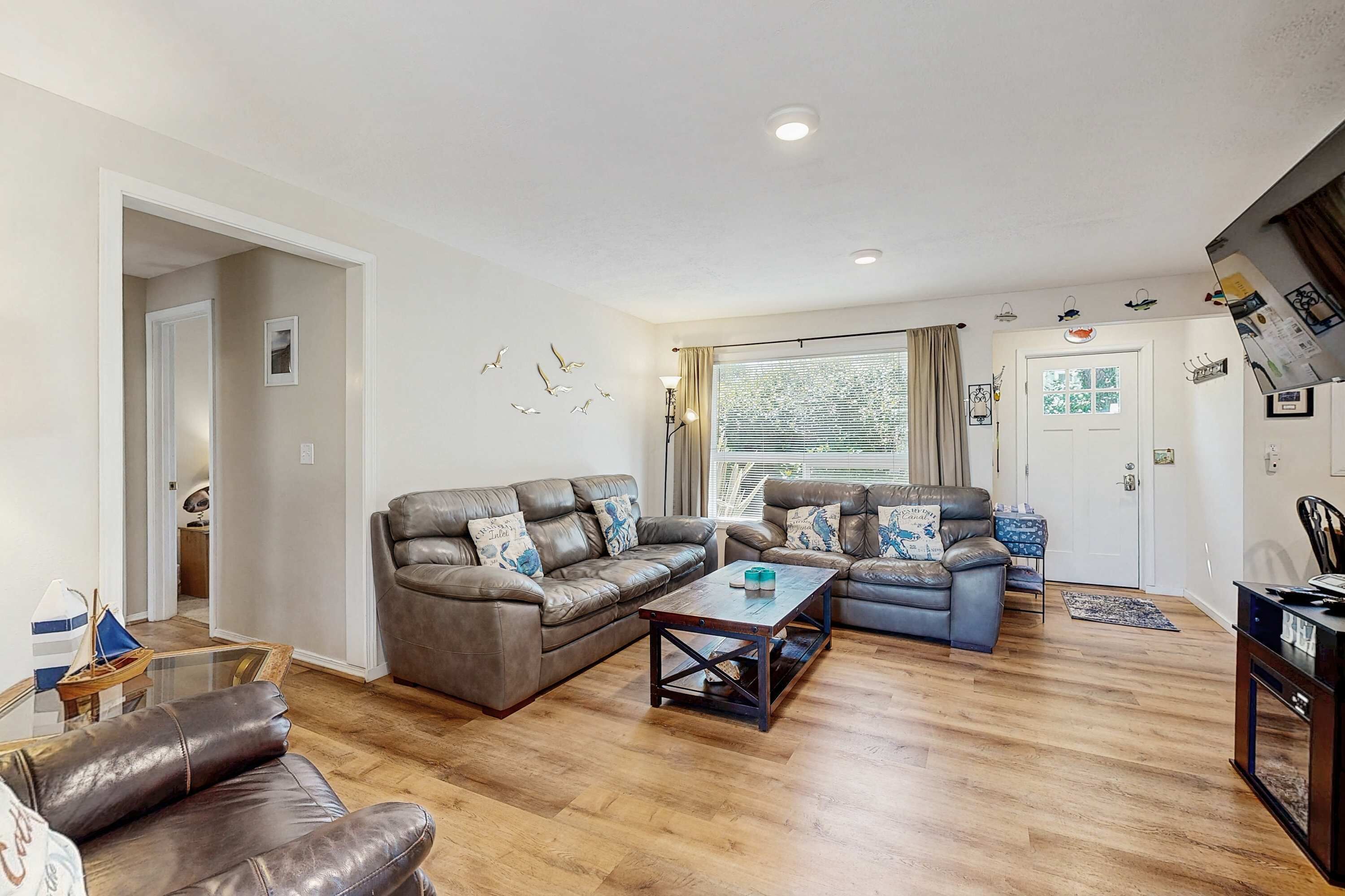 A living room with a brown leather sofa, a blue sofa, and a wooden coffee table.