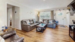 Una sala de estar con un sofá de cuero marrón, un sofá azul y una mesa de centro de madera.