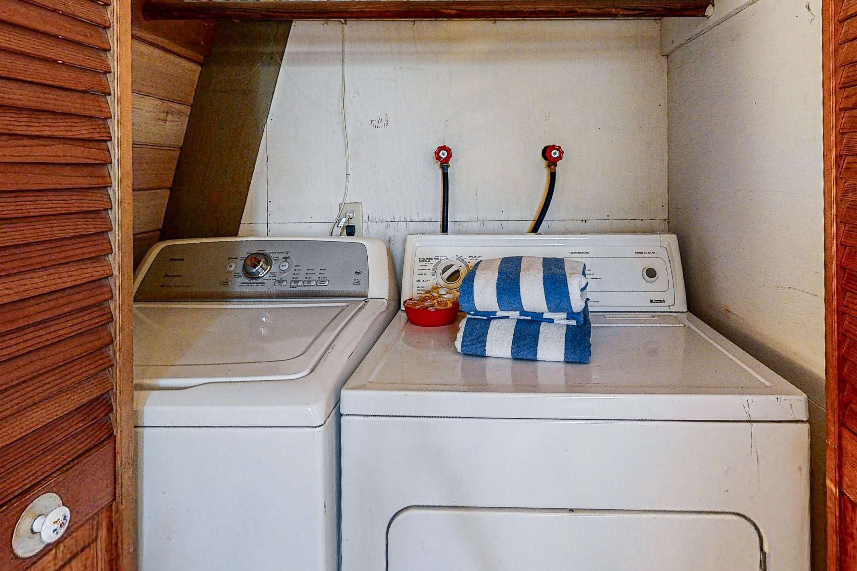 A compact laundry area with two washing machines and a drying rack.