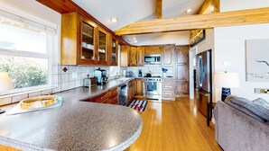 Una cocina moderna con armarios de madera, encimeras de granito, electrodomésticos de acero inoxidable y una isla grande.