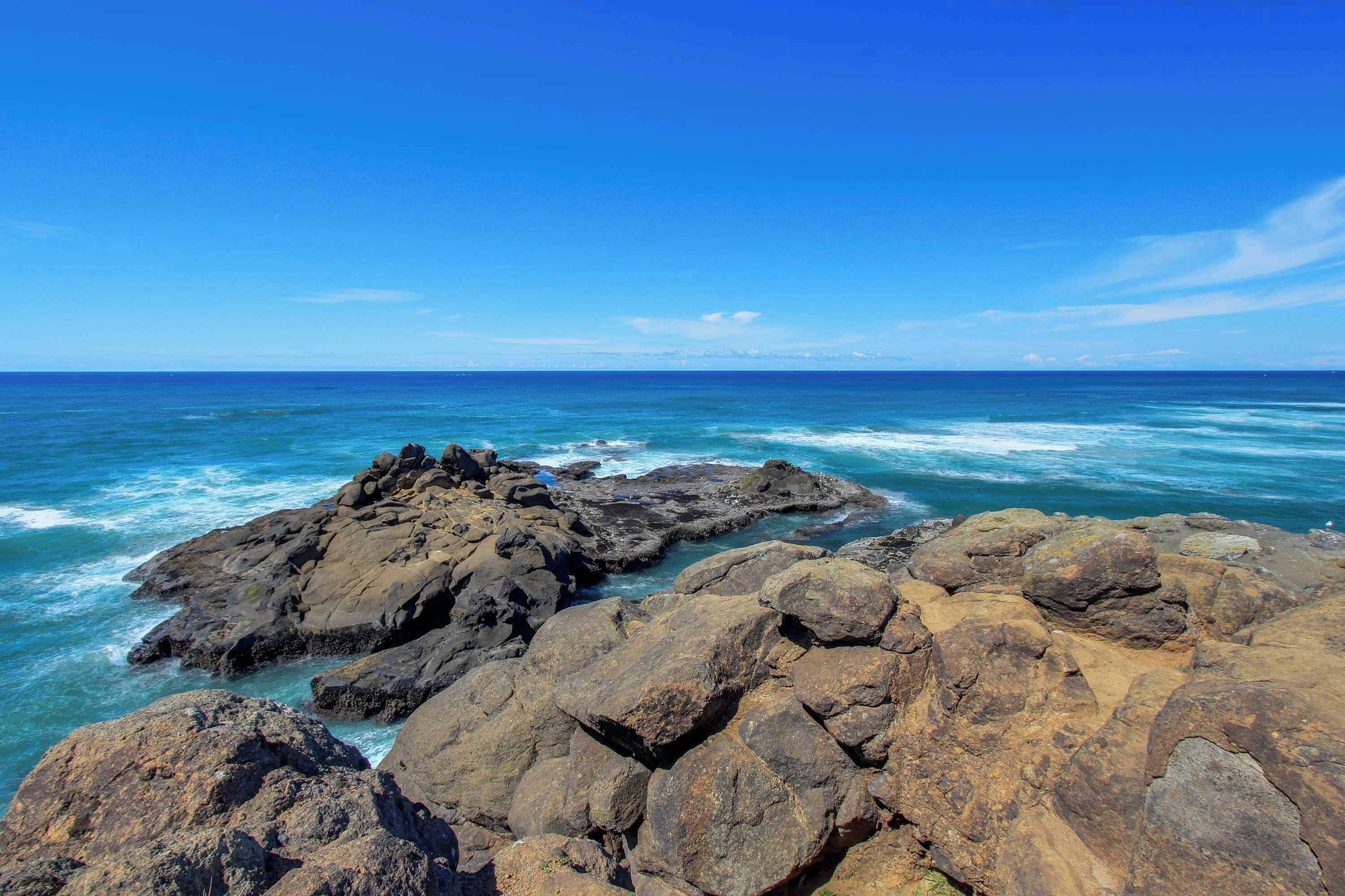 Una costa rocosa con olas rompiendo contra las rocas.