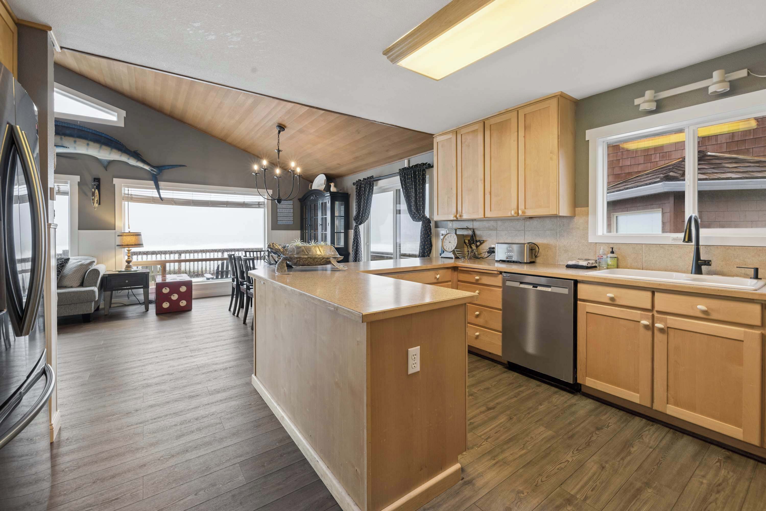 Una cocina moderna con armarios de madera, una isla central y un lavavajillas integrado.