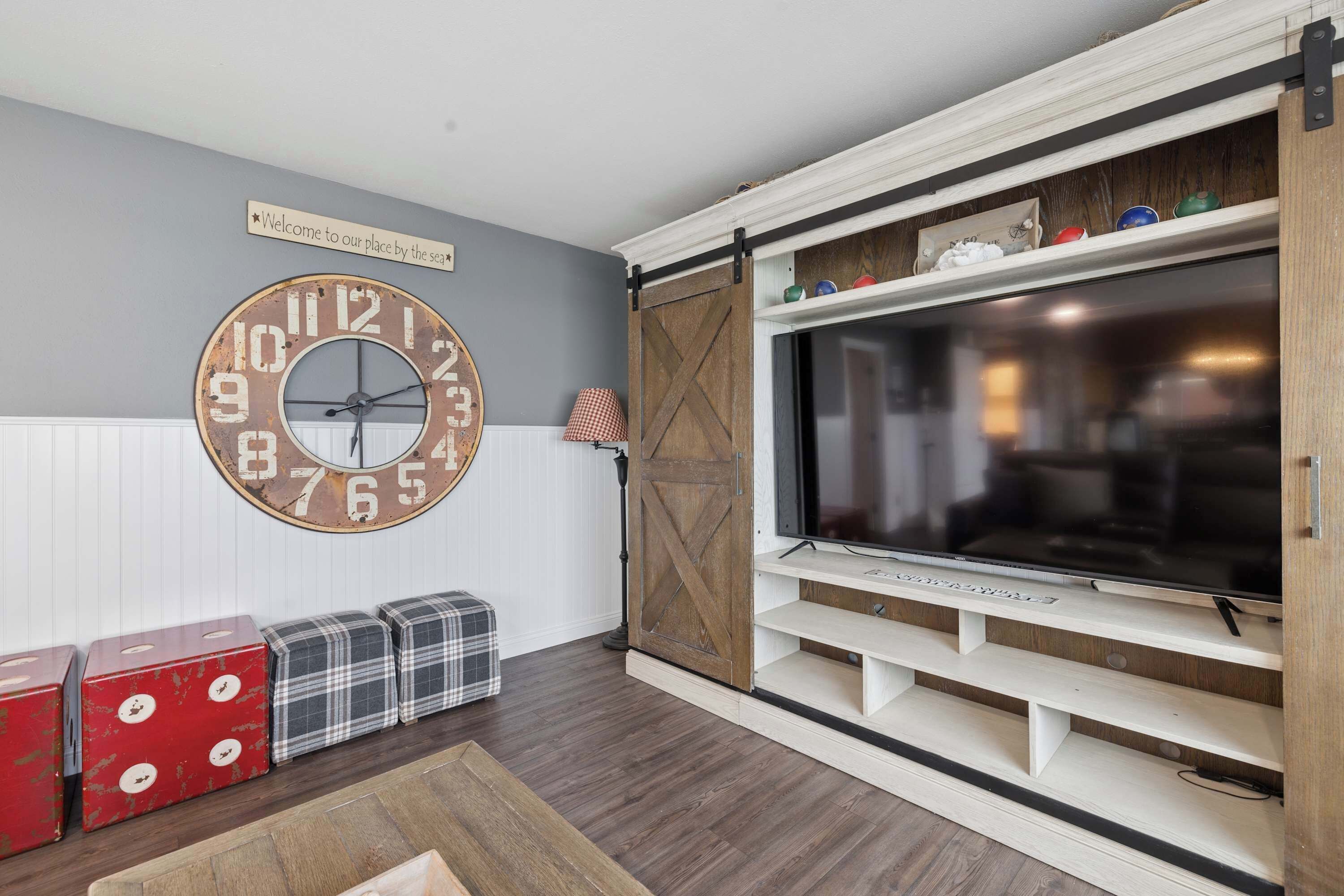 Una sala de estar con un reloj grande, un televisor y cajas de almacenamiento.