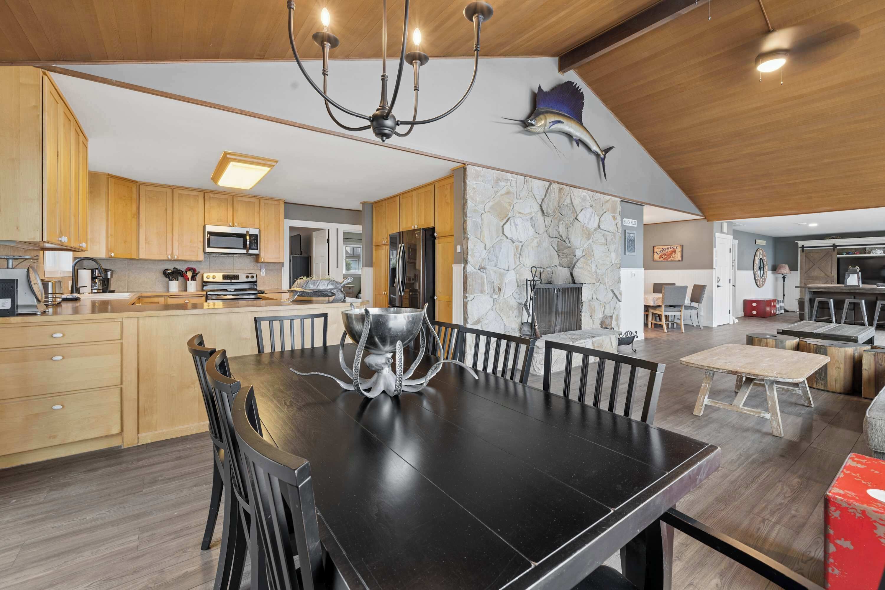 Una cocina moderna con armarios de madera, una mesa de comedor y una araña.