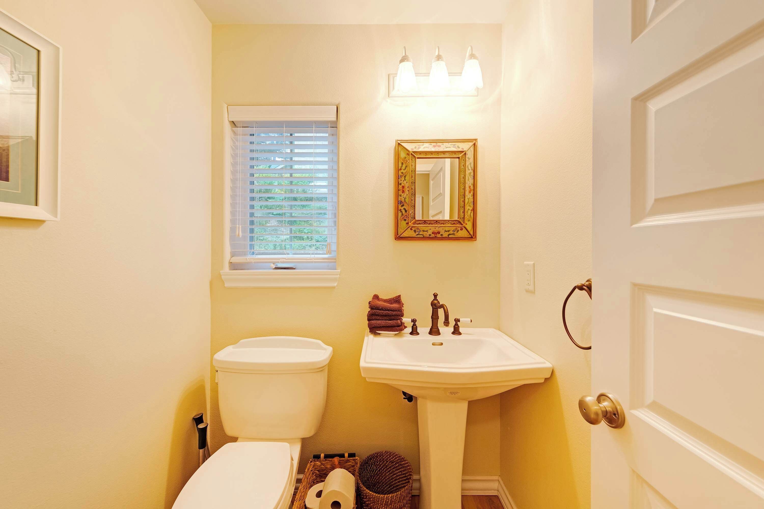Une salle de bain avec des toilettes, un lavabo et une fenêtre.