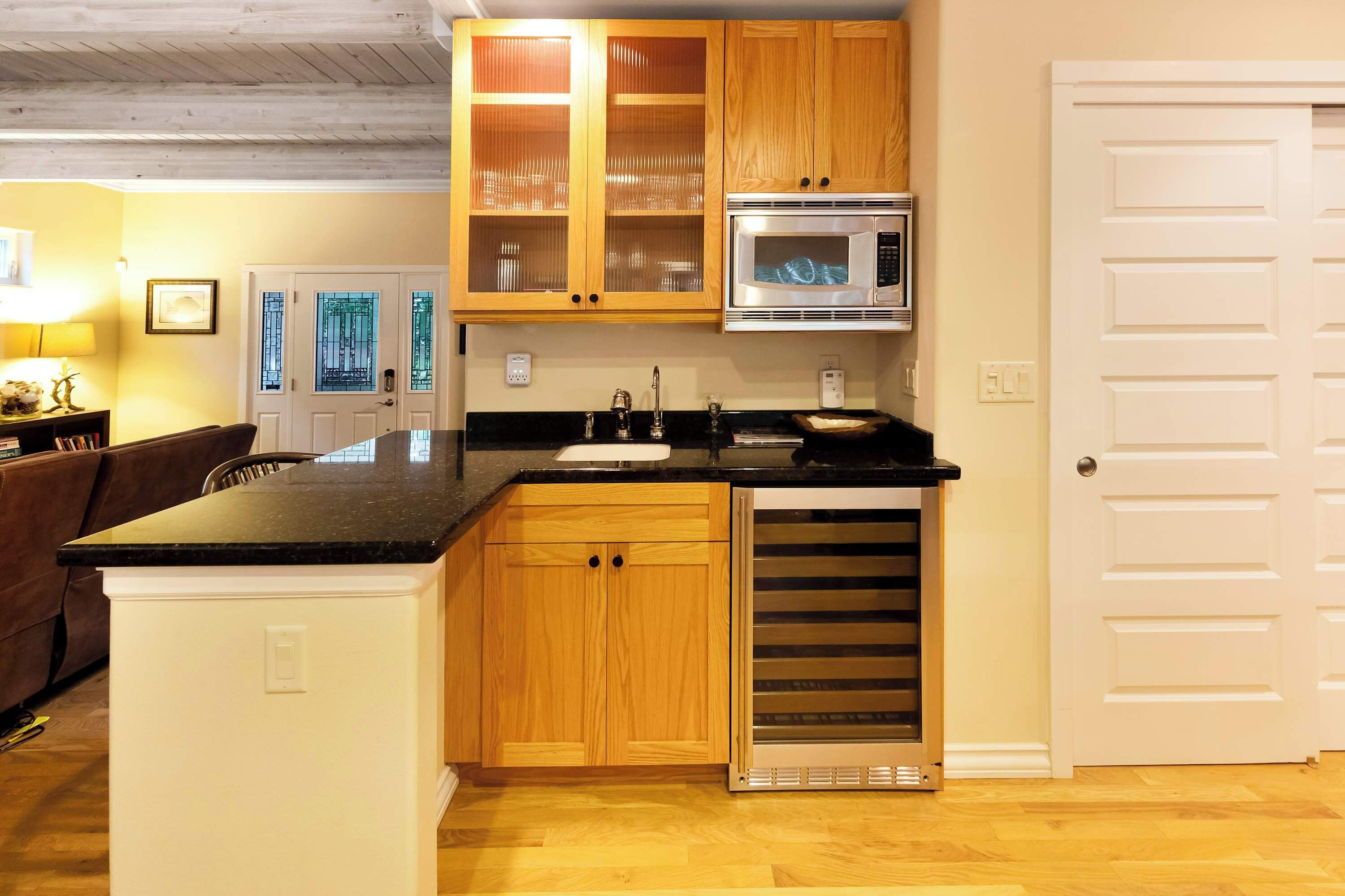 Una cocina con armarios de madera, microondas y horno empotrado.