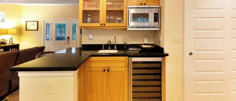 Una cocina con armarios de madera, microondas y horno empotrado.