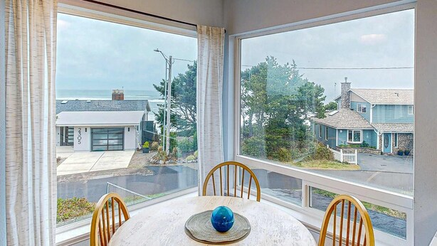 A dining area with a round table, four chairs, and a blue vase. - Cozy house close to beach hot tub and ocean views (Lincoln City)