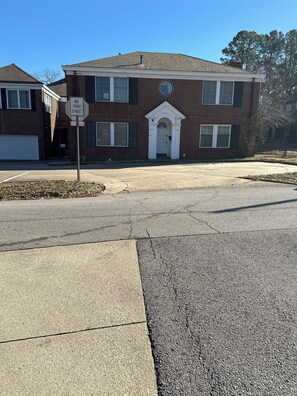 A two-story brick house with a garage, a driveway, and a 'No Through Street' sign.
