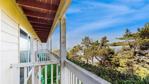 A balcony with a view of a beach and trees. - Lower Level Studio with Ocean Views and Easy Beach Access Dog Friendly (Lincoln City)