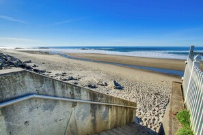 A beach with a concrete staircase leading down to the shore, a sandy beach, and the ocean in the background. - Easy Access Dog Friendly Studio with Ocean Views Short Walk to Beach (Lincoln City)