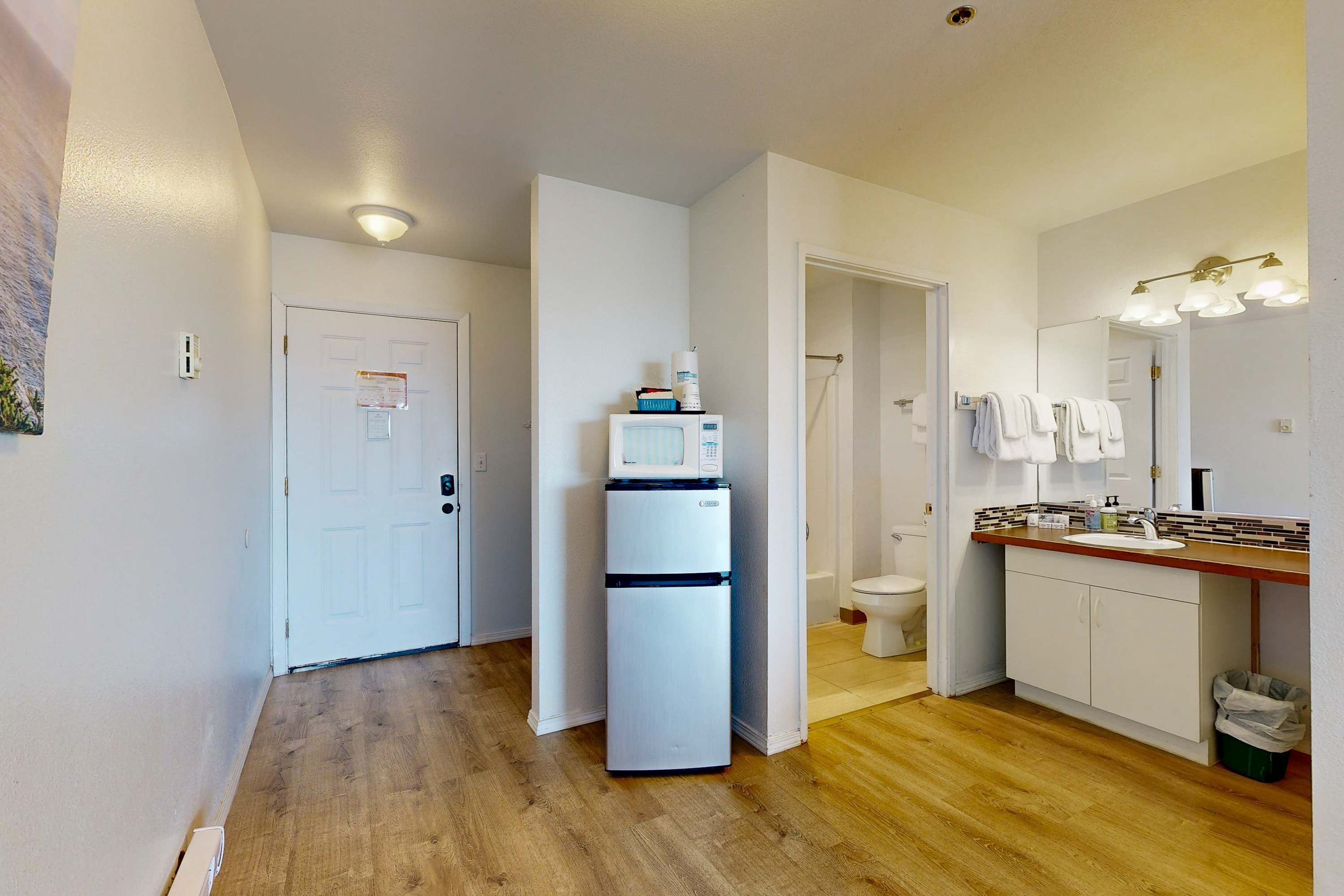Eine kleine Küche mit Kühlschrank, Spüle und Arbeitsplatte.