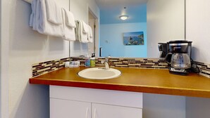 A bathroom with a sink, a mirror, and a coffee maker. - Oceanview Dog Friendly Studio with Awesome Views and Easy Beach Access (Lincoln City)