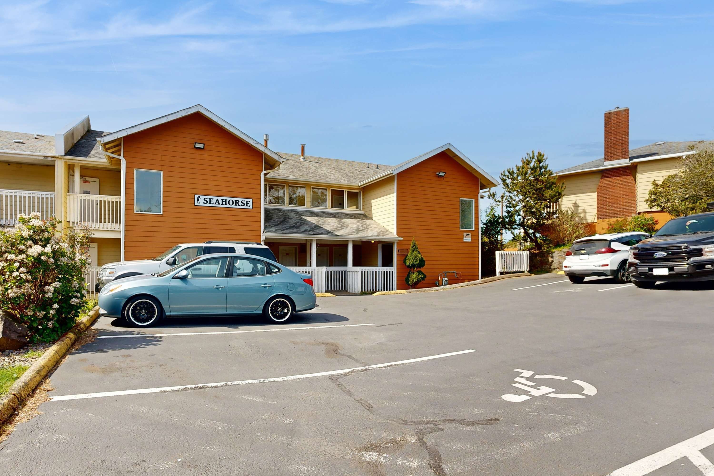 A parking lot with a blue car, a building labeled "SEAHORSE," and a bicycle lane.