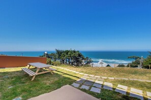 A patio with a picnic table overlooking the ocean. - Dog Friendly Suite with Ocean Views Balcony Free WiFi and Nearby Beach Access (Lincoln City)