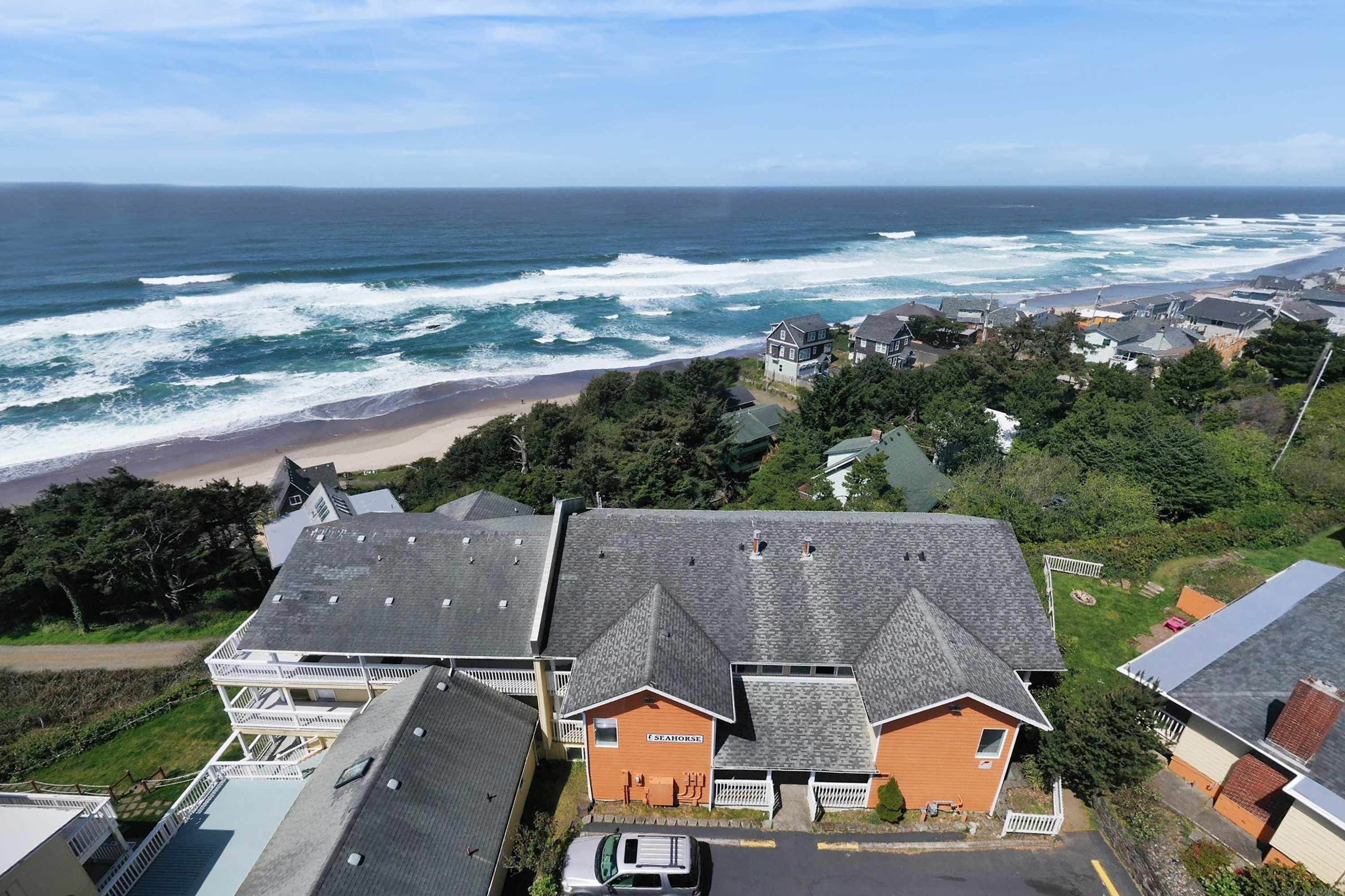 Una zona residencial costera con casas, una playa y el océano.