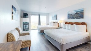 A hotel room with a large bed, two smaller beds, a sofa, a TV, and artwork on the walls. - Upper Level Studio with Sweeping Ocean Views Dog Friendly (Lincoln City)