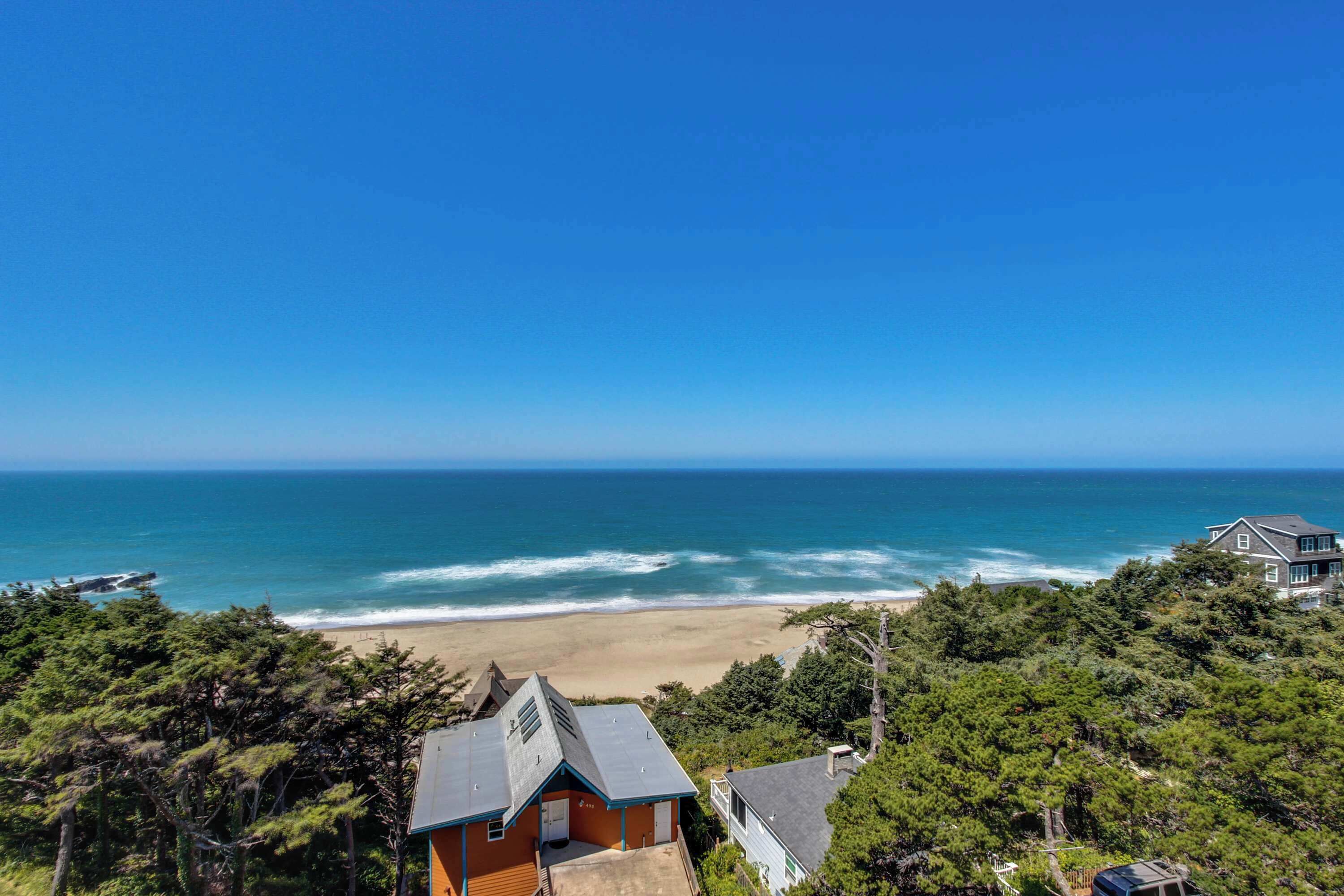 A coastal property with a beach view, surrounded by dense forest.