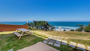 Une terrasse avec une table de pique-nique offrant une vue sur la côte.