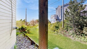Een woonhuis met een stenen gebouw, een gazon en een houten stulp.