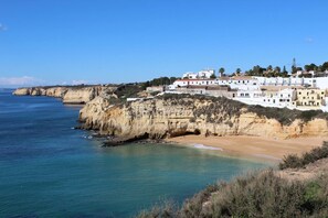 A coastal town with white buildings, a beach, and cliffs. - Dom Sancho Carvoeiro Luxury Beachfront Apartment (Carvoeiro)