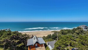 Una propiedad costera con vista a la playa, rodeada de un bosque frondoso.