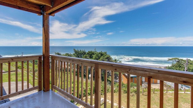 Un balcón de madera con vistas al océano.