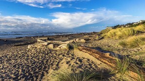 A sandy beach with dunes and a clear sky. - Luxurious and Spacious Renovated Condo with Gorgeous Ocean Views Dogs OK (Lincoln City)