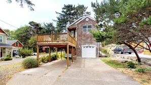 A two-story building with a wooden deck and a garage. - Spacious dog friendly home with WiFi and fireplace near the beach (Lincoln City)