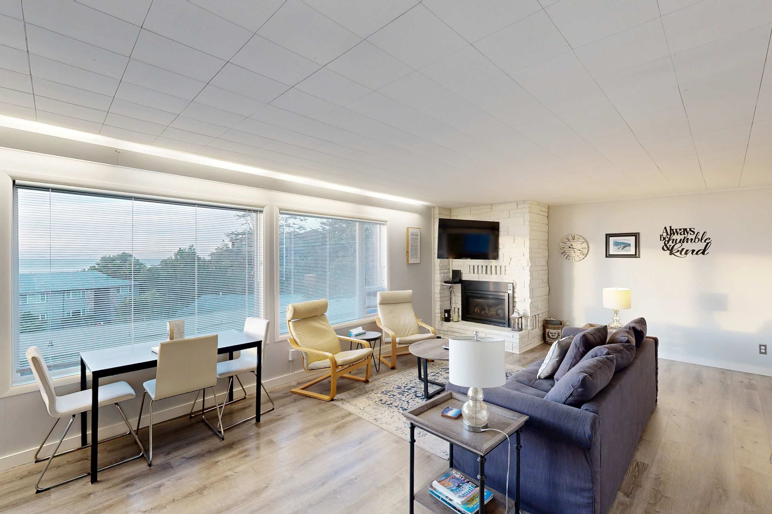 Una sala de estar moderna con un ventanal grande, una chimenea y un sofá.