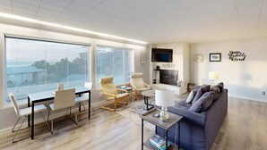 Un salon moderne avec une grande fenêtre, une cheminée et un canapé.