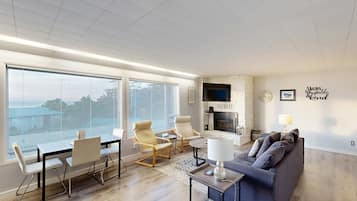 Una sala de estar moderna con un ventanal grande, una chimenea y un sofá.