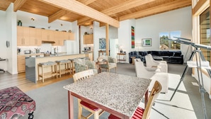 A spacious living area with a kitchen, dining table, and seating. - New home with unparalleled ocean views and private hot tub dogs welcome (Lincoln City)