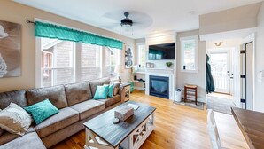 A living room with a sofa, coffee table, and fireplace. - Charming three story getaway with two cozy living areas walk to the beach (Lincoln City)