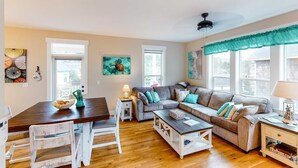 A cozy living room with a wooden dining table, a sofa set, and a coffee table. - Charming three story getaway with two cozy living areas walk to the beach (Lincoln City)