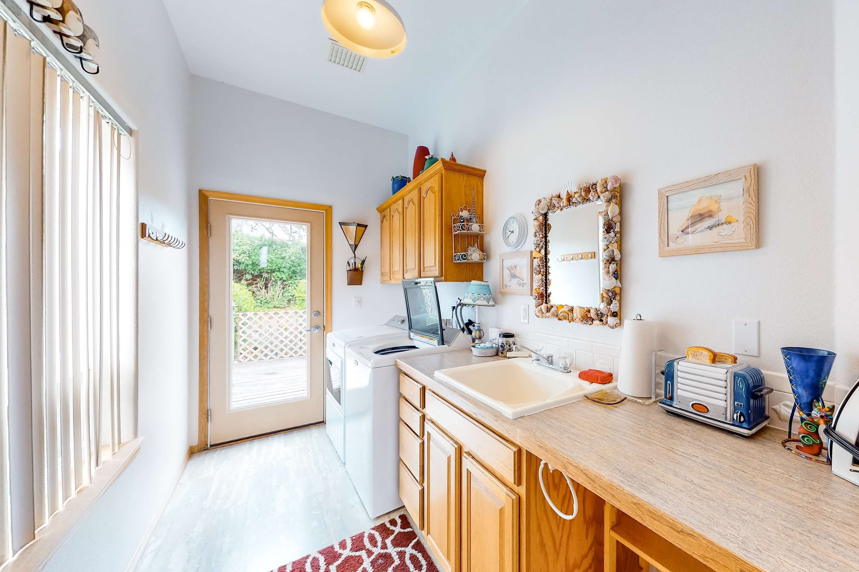 A kitchen with wooden cabinets, a sink, a toaster, and a window with blinds.