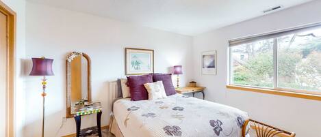 Une chambre à coucher avec un lit, des lampes de chevet, un miroir, une fenêtre et une chaise.