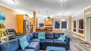 A modern living room with a sectional sofa, a dining area, and a kitchen. - Oceanfront condo with private hot tub ocean views and high speed WiFi (Lincoln City)