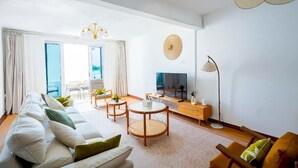 Un salon moderne avec un canapé, une table basse et un téléviseur.